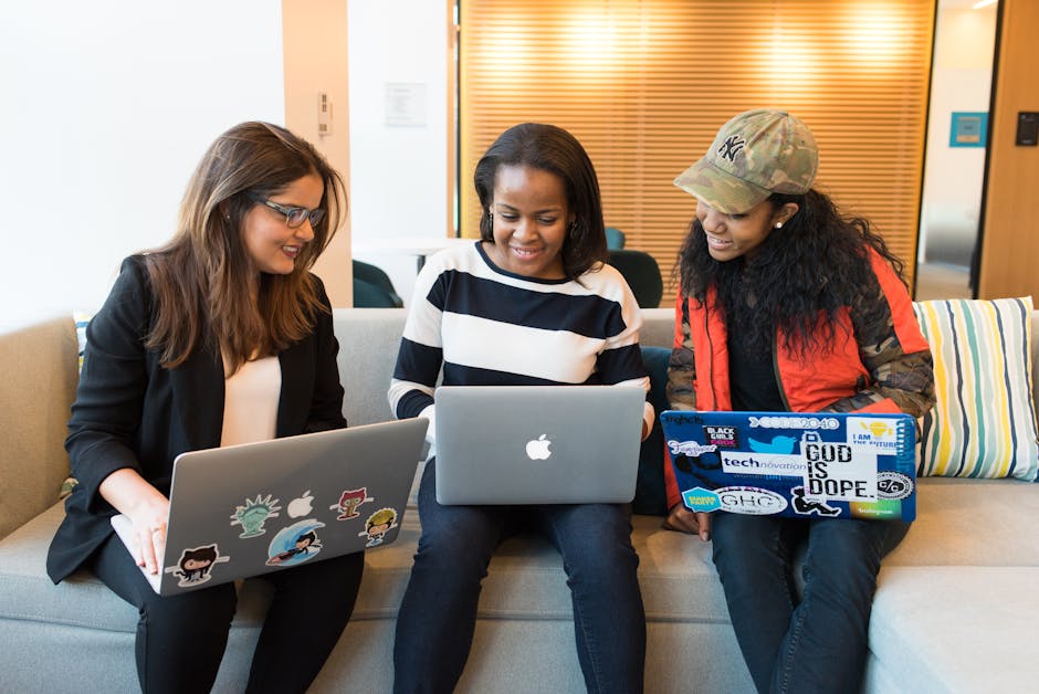 Three women working together on laptops in a casual office setting