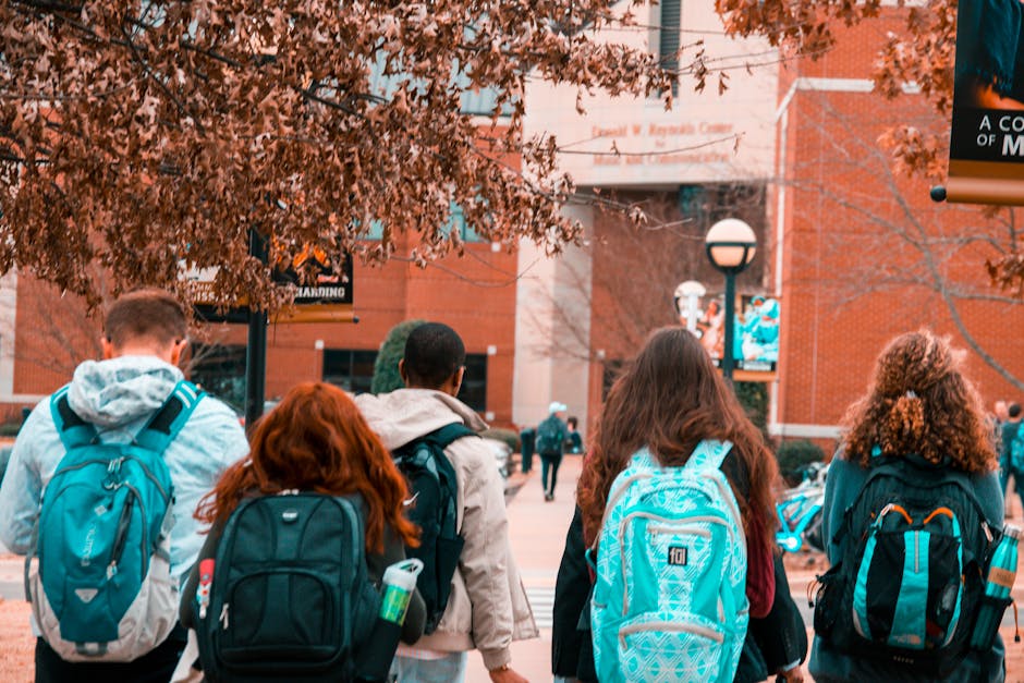 A group of college students with backpacks walking together outdoors on campus
